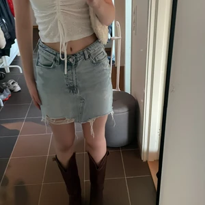 Jeans kjol med slitningar - As najs jeanskjol från hm. Jätte skön att bara slänga på sig till stranden✨ Använd ganska många gånger men är ändå i väldigt bra skick!:)