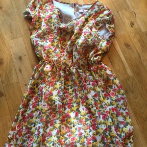 Blommig volang klänning S - Blommig mellan kort volang klänning i st. S. Sommar klänning tunn nästan genomskinlig upp till med resor runt sen tunna volanger i lager vilket tillger lite tjockare lager ner till. Aldrig använd.