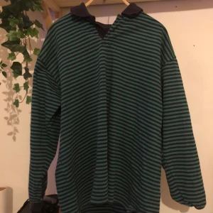 Grön Svar randig tjocktröja - Säljer igen pga oseriös köpare. Brutalt cool tjocktröja med svarta och gröna ränder, Plus en svart krage. En av knapparna har ramlat av så antingen helt öppen eller helt stängd krage. Frakt ingår