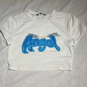 Vit ”angel” t-shirt från Shein - vit croppad t-shirt från Shein! Knappt använd💙 storlek S och den är normal i storleken. fraktar endast - två frimärken - 26kr💫