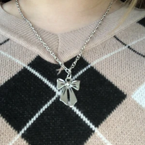 Silvrigt halsband  - Ett silvrigt halsband med en rosett, perfekt till vardags eller till finare tillfällen.