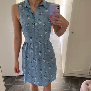 Klänning strl 38 - Blå klänning med vita blommor, använt ca 1 gång. Jätte fin detalj i ryggen som är lite öppen! Köparen står för frakten