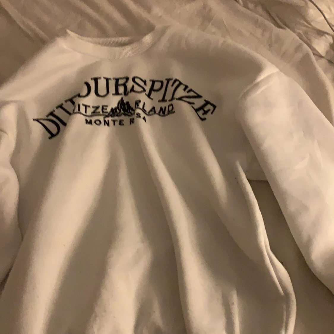 vit tjocktröja med text