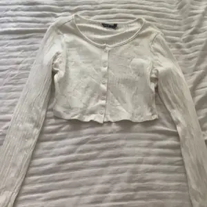 En super fin vit croppad tröja med knappar som man kan knäppa upp om man nu vill det eller bara ha alla stängda