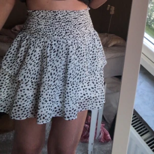 Volangkjol - Vit kjol med svarta prickar. Bra längd(enligt mig) och är oanvänd.