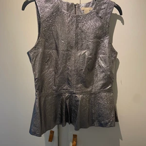 Skinntopp  - Silverfärgad topp i äkta skinn från H&M Trend. Knappt använd. 