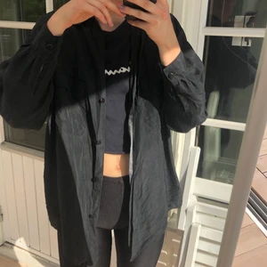 Svart skjorta - Svart skjorta i lite tunnare material, perfekt som knytskjorta! Jätteskön att ha på sommaren då den är så tunn. Står ingen storlek men känns som M ungefär. Jag är xs på bilden. En knapp har lossnat men man kan knäppa som på bild 2.