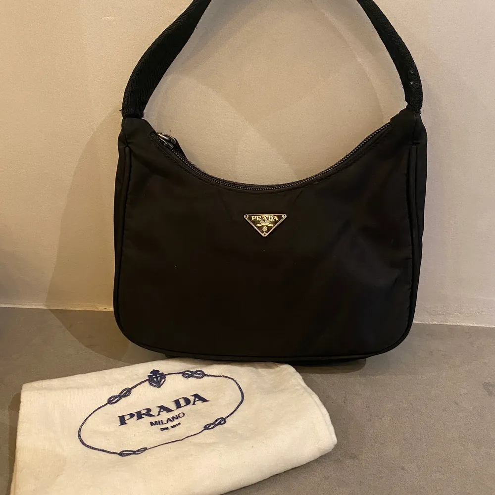 Äkta Prada Re Edition Bag. Mycket fint skick. Tyghandtag. Mått: 22cm x 17cm x 6cm. Väskor.