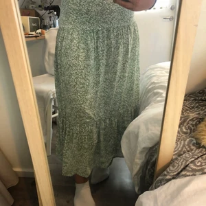 Kjol - Fin somrig kjol med grönt tyg med vita blommor på. Sitter super fint och råkade köpa två så säljer en.