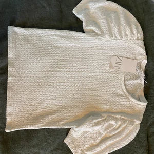 Blus från Zara - Jättefin helt oanvänd blus från Zara i vit smock. Lappen kvar! I storlek L men passar S-XL då den är så stretchig. Köpt för 299kr