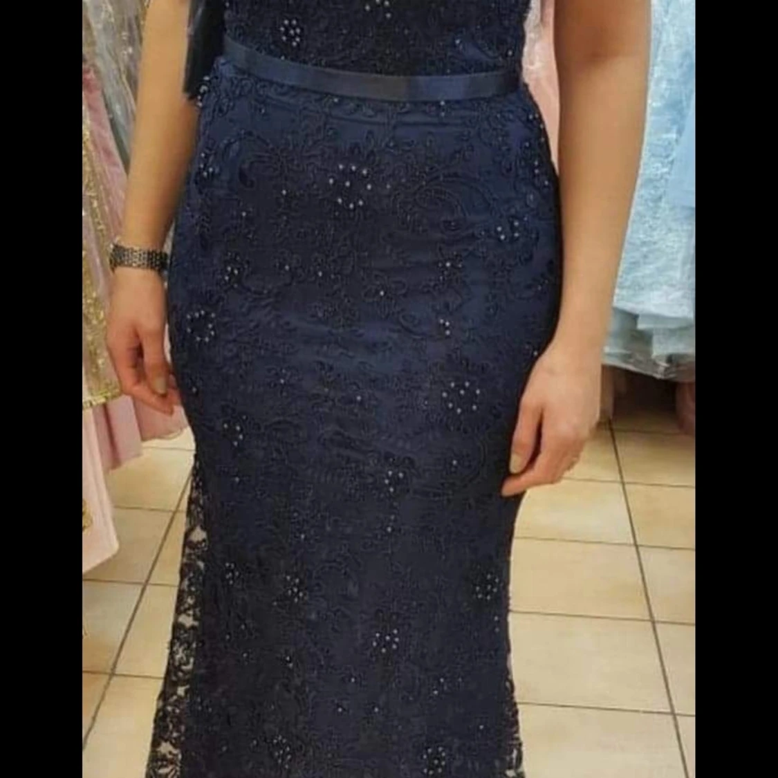 En supersnygg tight klänning i mörkblå med fina detaljer över hela plagget.  - 90
