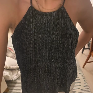Glittrig topp! - Enkel glittrig topp från H&M med halter neck. Inga slitage - väldigt fint skick! 