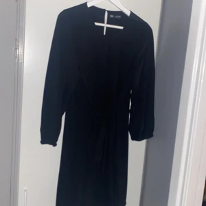Svart klänning från Zara - Svart klänning med band i midjan från Zara. Kort modell och finare tyg. Aldrig använd. Storlek L.
