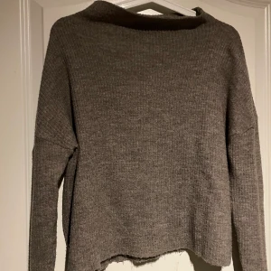 Beigegrå stickad tröja  - Väl använd beigegrå stickad tröja med slits i armen. Köpt på new yorker. Köparen står jävla för fraktkostnaden 