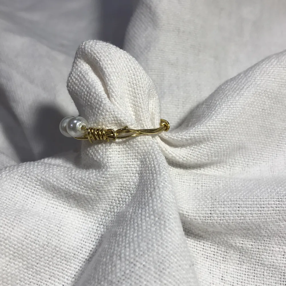 En hemmagjord ring med 4 vita pärlor på och metalltråden är i färgen guld. Passar bra till mycket. 61 med frakt 🚚 . Accessoarer.
