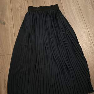 Plisserad kjol från Italien. Inga fläckar eller andra anmärkningar. Mörkblå/marinblå i färgen med resorband i midjan.