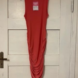 APRIKOS FÄRGAD KLÄNNING STL M - Aprikos färgad klänning i storlek M. ”ruched” på sidorna. Aldrig använd med prislappen kvar. Budgivningen startar på 80 kr i komentarsfältet, Köp direkt för 140 kr!  (Ljusare i verkligheten)