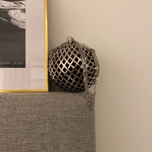 Klotformad aftonväska  - En klotformad aftonväska i marinblått sammet och silverdetaljer. Kedjan som medföljer kan justeras. Super fin väska som kan användas till middag,fester, bal, bröllop, nyårsfest m.m. I topp skick, då den endast är använd en gång. 