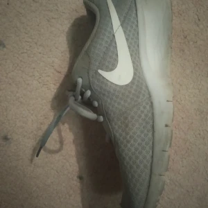 Skor - Gråa Nike skor som jag har köpt för 400 kr för mindre än ett år jag slutade använda dom när de fick två små hål på var ok en av skorna men annars är de ganska bra skor,det är i storlek 37,bara för att dom har hål så säljer jag dom billigt