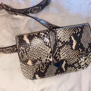 Midjeväska  - Orm liknade mönstrad väska. Aldrig använd och kommer från Lindex. Det finns ganska många olika hål så man kan sjystes den. 