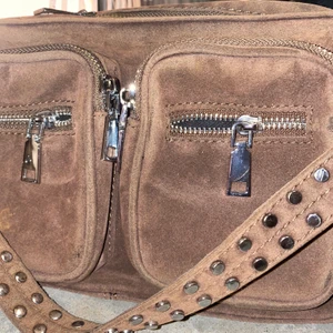 Noella nougat väska  - Nougat färgad väska med silverdetaljer. I mycket fint skick, rymlig och praktiskt att ha med sig överallt. 