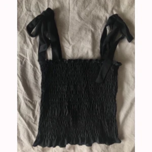 Topp - Svart topp som man knyter på axlarna. Passar till allt typ!