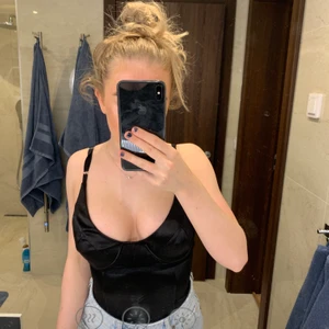 Boohoo bodysuit - Svart silkes body med inbyggd bygel. Bodyn är i XS. Säljer pga förliten över brösten!