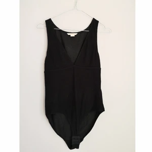 Djupt v-ringad body - Stl. S, Lite nopprig men annars i fint skick. 