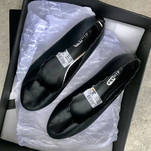 Söta svarta klassiska ballerinaskor från - Söta svarta klassiska ballerinaskor från Dinsko.   Märke: Dinsko.  Storlek: 36 Ballerina i svart skinnimitaition där kanten är utskuren i vågigt mönster vilket ger en superfin effekt på foten. En stilsäker sko som passar till allt!   Pris: 60 kr + frakt 57 ( spårbart)  Skick : Dem är sparsamt använda, har inget direkt att anmärka förutom två repor på kan sen knappt syns. se bilder.  🌸Övrigt kläderna kommer från  rökfritt 🚭 , djurfritt 🐈 🐕 hem. 