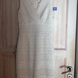 Vit spetsklänning - En klänning som är lätt v-ringad. Klänningen är i spets, med en vit underklänning. Det är lite slits där bak. Storlek 36 och passar mig som är 38. Säljer då den inte kommer till användning. Säljer för 100kr, kom gärna med egna bud🥰