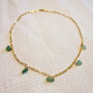 Guldfärgat halsband med små kristaller av grön aventurin 💎 Kedjan är ca 40 cm lång, och passformen går att justera. Skickas i vadderat kuvert via postnord. 
