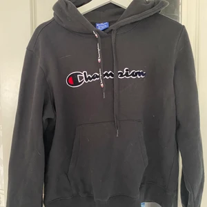 En hoodie  - En champion hoodie i svart! Ljuset på bilden kan göra att den ser grå ut men det är svart! Superskön och snygg hoodie dock kommer den inte till användning här hemma:/ hoodie är i bra skick och har bara används några få gånger! Passar både tjejer och killar!