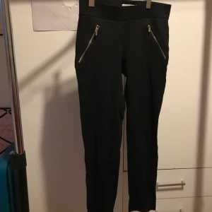 Svarta byxor - Svarta tajta byxor med dragkedja detalj i fickorna. Passar storlek XS/XXS