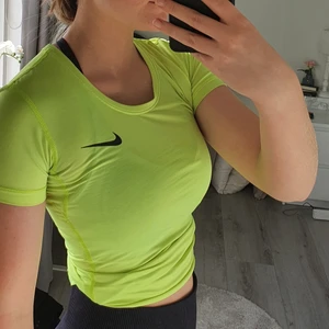 Träningströja - Säljer denna grön/gula nike T-shirten! Superskönt stretchigt material som andas bra. Tröjan är tajt och lite längre, på första bilden är den uppvikt💕  knappt använd.                                                  70 kr + frakt 45 kr eller 66 kr spårbart!  (köparen står för frakten), betalning via swish
