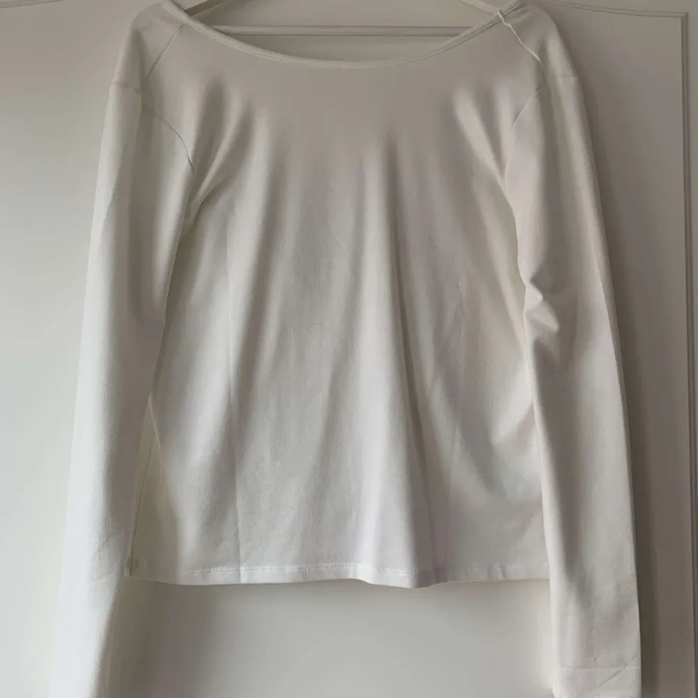 En jättefin vit långärmad tröja med en djup rygg. Fin vardagströja som också går att klä upp. Den är från Nakd i storlek S och är endast använd en gång vilket gör att den är i mycket fint skick. Säljs pga att den inte används längre💕💕. Tröjor & Koftor.