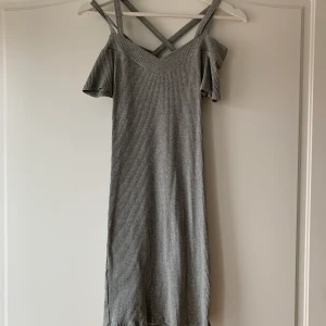 Fin grå klänning  - En fin och bekväm i klänning i storlek s från voyelles. Klänningen är i ribbat material med korsande band på ryggen. Den går att ha både offshoulder eller med ärmarna uppe. Är i fint skick och har använts en gång💕💕