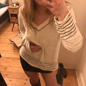 Stickad v-ringad tröja  - Vit tunn stickad tröja med mörkblå/svarta detaljer 🖤💙 köpt second hand Superfin passar till mycket! Sitter lite oversized 👌 Jag har storlek S/XS o den sitter såhär på mig
