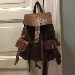 Ryggsäck i skinn - Jättefin ryggsäck i äkta skinn med kontrastsömmar! Köpt i Spanien, Inga defekter. Ett kap om du frågar mig🌸🦋 Köparen betalar frakt ca 50kr