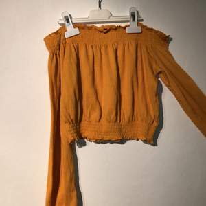 Söt off-shoulder topp i gul/orange! Endast använd ett fåtal gånger så superfint skick!