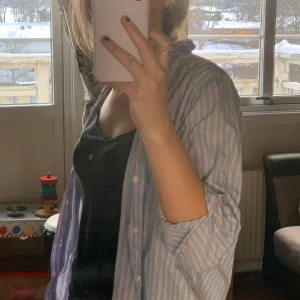 Skjorta  - Supersöt skjorta. Rosa/beige/blå randig färg. Står inte vad det är för storlek men hade gissat på en XS. inte fullängd i ärmarna.