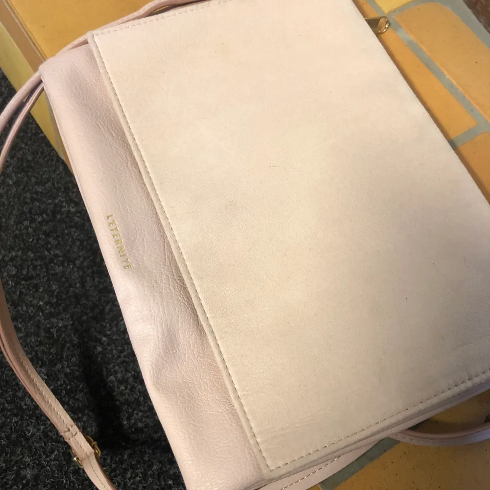 Ljusrosa väska i mockaimitation på framsidan och läderimitation på baksidan. Använd fåtal gånger. Kan bäras både som axelremsväska eller som kuvertväska. . Väskor.