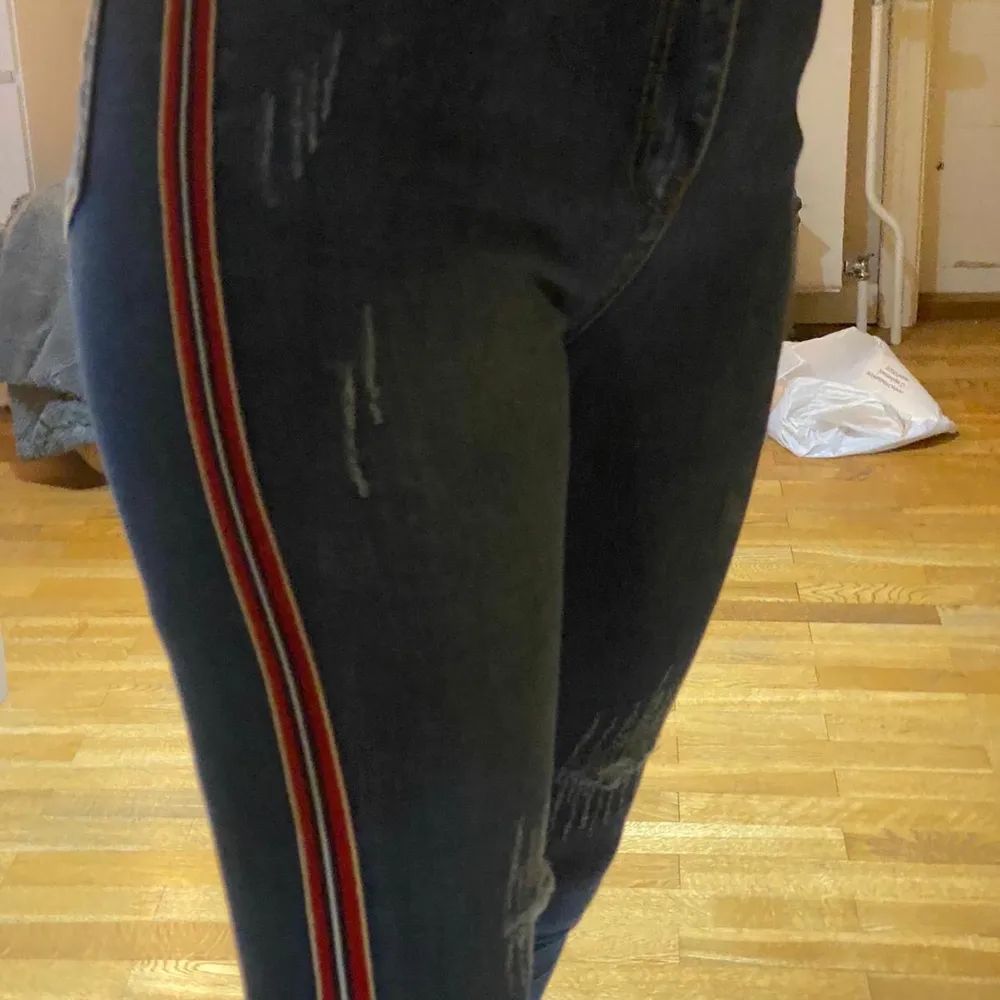 Blå jeans med röda detaljer på sidorna🧸 har även små hål vi knäna/ låren🧸. Jeans & Byxor.