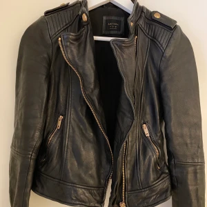 Jacka i äkta skinn - Jättesnygg svart jacka i skinn från Zara. Väldigt mjuk och fin i lädret. Snygga detaljer i rosé. Storlek S. Dm för fler bilder om det önskas