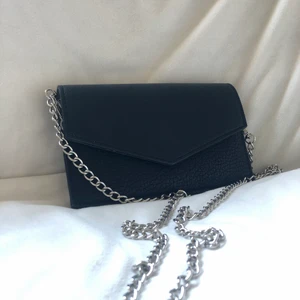 Väska  - Svart Kuvertväska i skinn. Avtagbar axelrem.  Perfekt för balen, bröllop eller en utekväll. Finns i Silverdalen, kan även skickas, frakt står köparen för. 