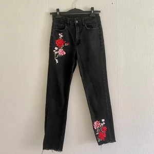 Svarta jeans med brodering - Svarta momjeans från H&M med broderade rosor. Två på framsidan och en på höger bakficka. Storlek 38. 
