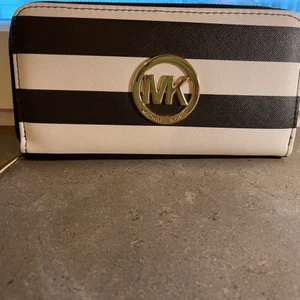 Michael kors plånbok  - Svart och vit randig plånbok finns korthållare finns plats för små kronor och sedlar stor o rymlig använd Max 3 Gng som ny 