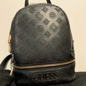 Guess ryggsäck  - Säljer min guess ryggsäck för 800kr (köpt för 1300-1400) fräsch och fin/ren insida lite märken enbart på plumparna längst ner som ni ser på bilden, fler bilder kan skickas vid intresse! ❤️