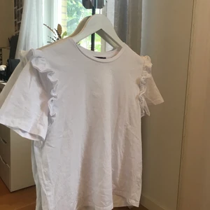 Zara topp - Jättefin och söt t-shirt med volanger vid ärmen!! Köpte i somras men kommer tyvärr inte till användning. jättebra skick eftersom den är oanvänd. Storlek M, köpte normalpris för 190 kr på zara