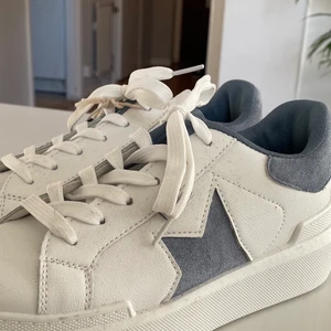 Oanvända vita sneakers med stjärna - Supercoola oanvända skor med lappen kvar, cool blå stjärna⭐️💙 Skorna är i konstskin och imitations mocka, storlek 37!