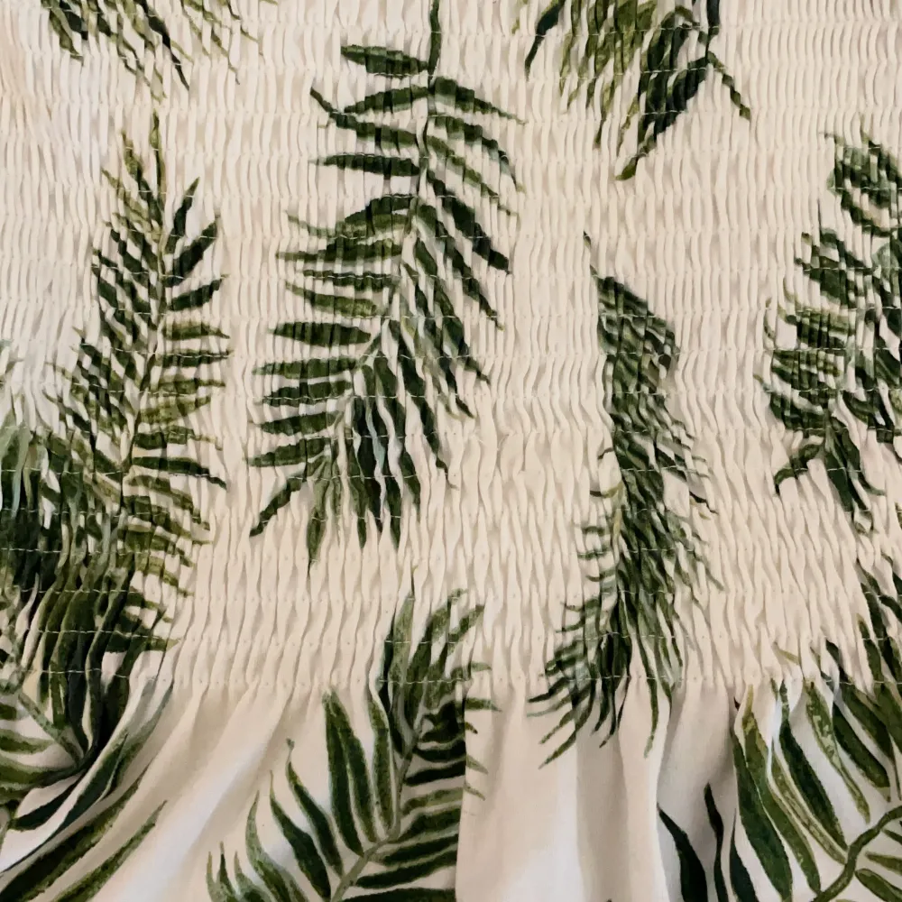 Aldrig använd är linne från HM. Vit med gröna palmblad stl M. Toppar.